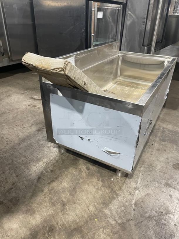 Regency stainless steel ice bin with up-turned backsplash, legs, and visible scratches; condition: scratch-n-dent.