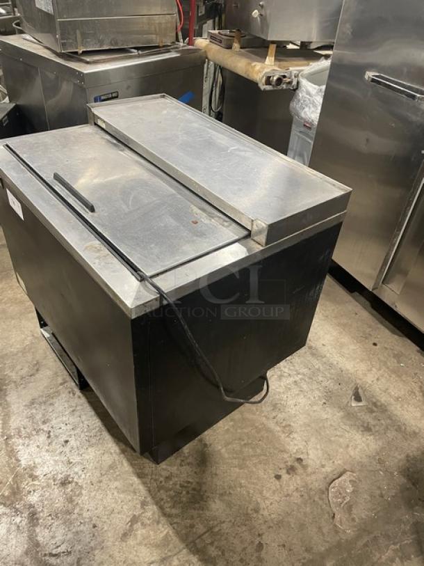 Beverage-Air commercial bottle cooler; black powder-coated steel with stainless steel easy-slide lid and poly coated wired rack.