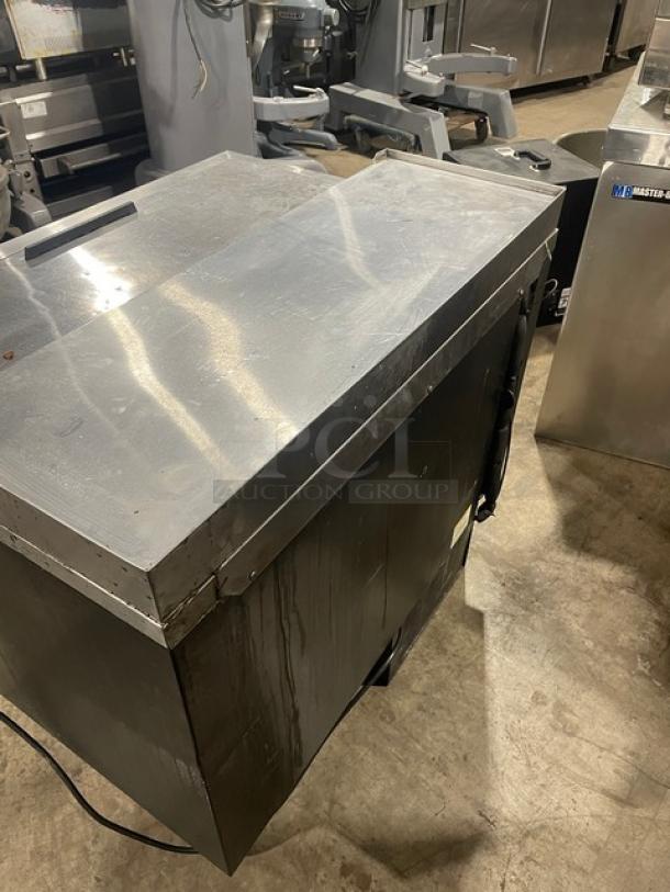 Beverage-Air commercial bottle cooler, black powder-coated and stainless steel, easy-slide lid, poly-coated wired rack, used.