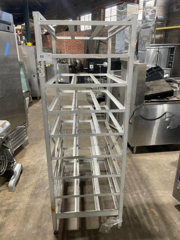 Commercial stainless steel can rack on legs, with multiple horizontal shelves, used in good condition. Suitable for storage.