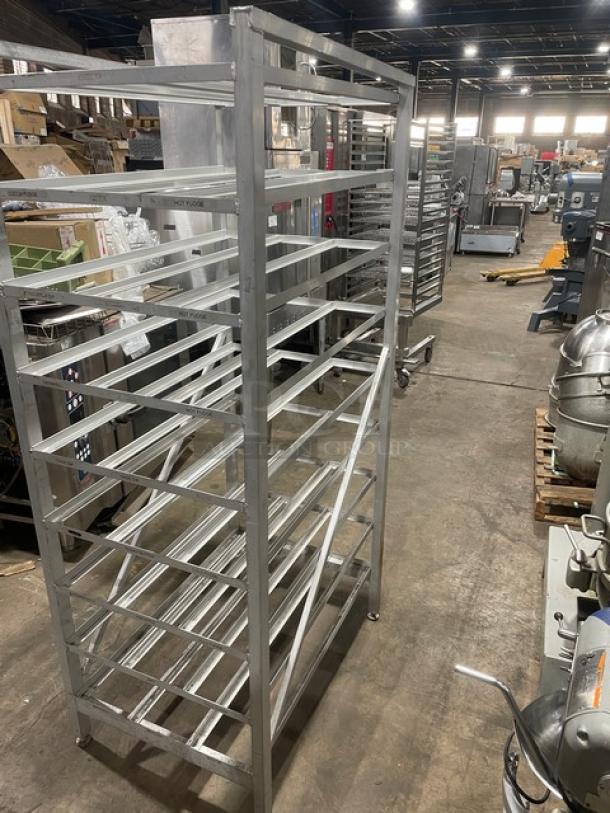 Commercial stainless steel can rack on legs, used, multiple shelves, industrial-grade, suitable for kitchen storage.