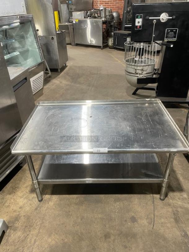 Commercial stainless steel food prep table with under-shelf and legs, used condition, ideal for kitchen or restaurant settings.