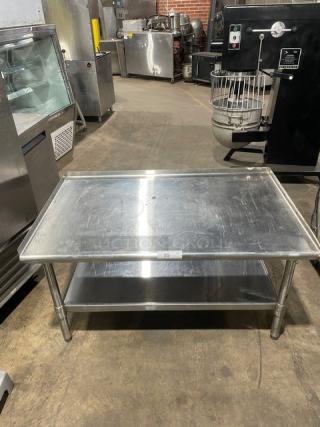 Commercial stainless steel food prep table with under-shelf and legs, used condition, ideal for kitchen or restaurant settings.