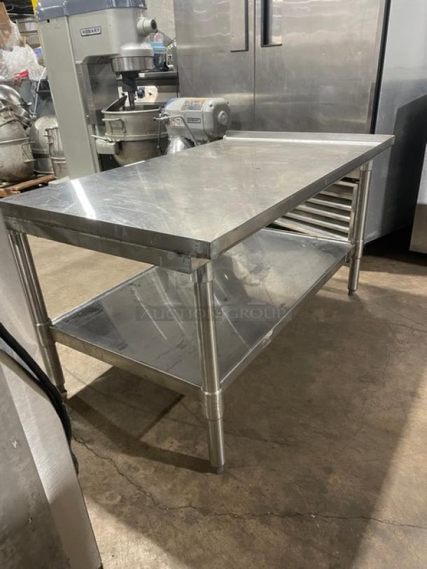 Commercial stainless steel food prep table with under-shelf, on legs. Used, sturdy construction. Ideal for kitchen use.