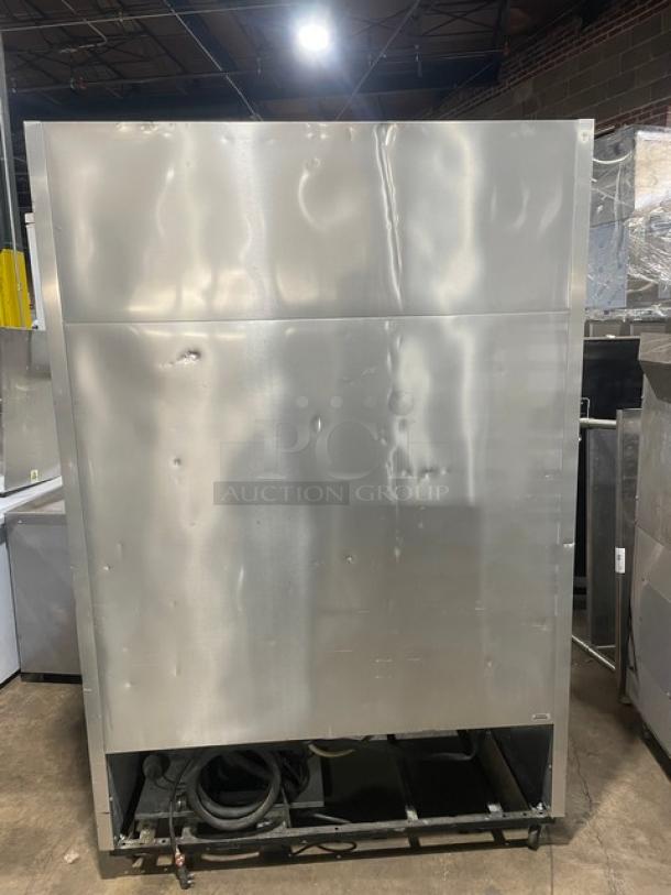 True T49F commercial stainless steel two-door freezer on casters, with visible exterior wear and poly coated wire racks.