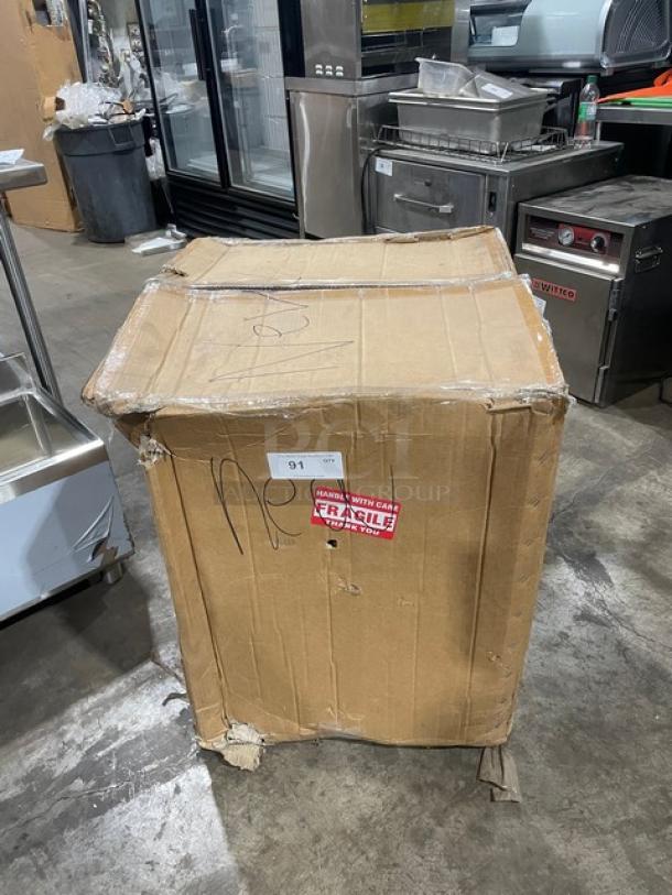 Damaged cardboard box containing Cozoc PW5002-10-18 electric pizza warmer with "Handle with Care" and "Fragile" labels.
