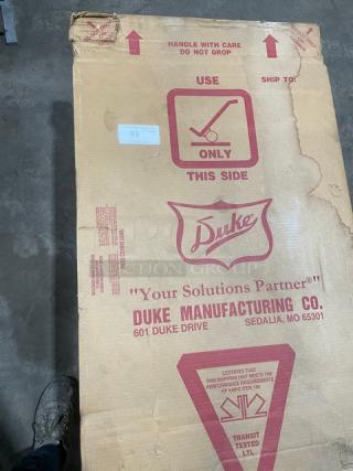 New Duke Aerohot Series stainless steel electric steam table in box, features 3 wells, cutting board, on legs.