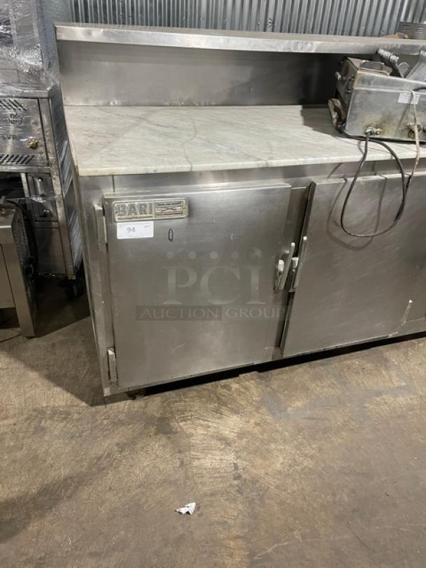 Stainless steel Bari 2-door refrigerated pizza dough retarder table with marble top on legs. Electric powered, commercial use.