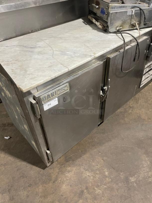 Bari commercial stainless steel 2-door refrigerated pizza dough retarder table with marble top and label. On legs.
