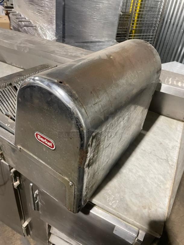 Berkel stainless steel electric countertop bread slicer, commercial grade, visible wear, red Berkel logo on side.