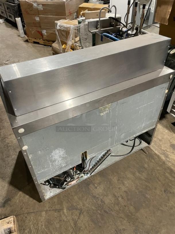 Delfield commercial refrigerated salad bar/sandwich prep table in stainless steel with four refrigerated drawers. Some wear visible.