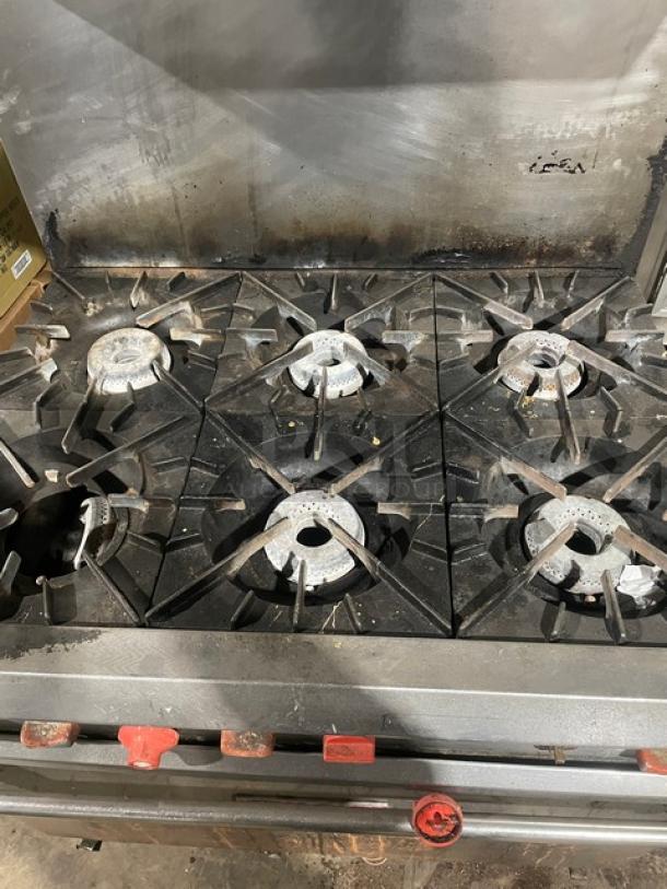 Vulcan commercial 6 burner stainless steel range/oven combo, natural gas, with overhead salamander shelf and backsplash.