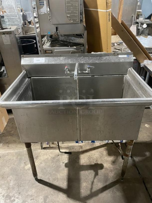 Stainless steel 2-compartment dishwashing sink with faucet and legs. Used condition. Perfect for commercial kitchens.