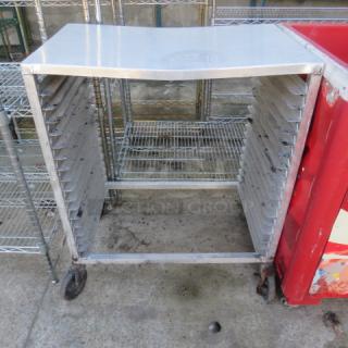 Aluminum speed rack on casters, 20.5x26x40 inches, used condition, 10 tray slots. Ideal for bakery or kitchen use.