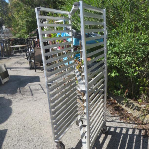 Aluminum speed rack on casters, 20.5x26x70 inches, holds multiple trays, durable, outdoor setting, good condition.