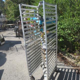 Aluminum speed rack on casters, 20.5x26x70 inches, holds multiple trays, durable, outdoor setting, good condition.