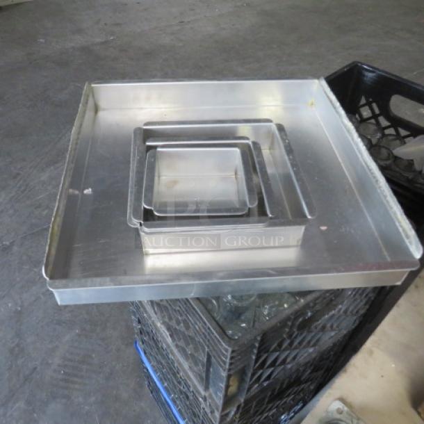 Assorted size baking pans stacked; three square pans made of metal in varying dimensions. Used condition.
