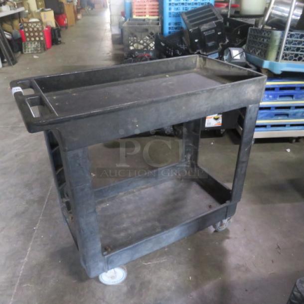 Poly two-shelf utility cart on casters, black, used condition. Two-tier design with handle, ideal for moving items.