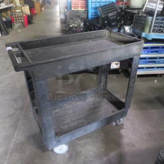 Poly two-shelf utility cart on casters, black, used condition. Two-tier design with handle, ideal for moving items.