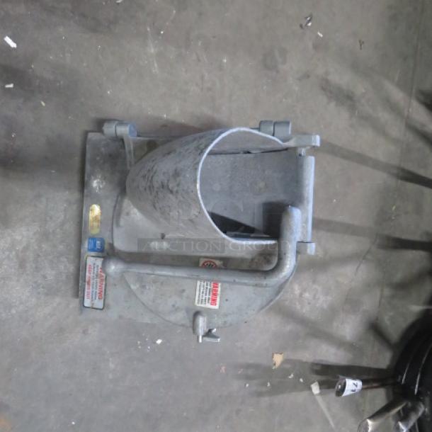 Metallic One Pelican Head Attachment in used condition, features mounting base, clamps, and visible caution labels indicating safety guidelines.