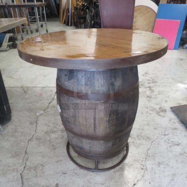 Whiskey barrel bar height table with wooden top, 41x42 inches, rustic finish, metal ring accents, excellent condition.