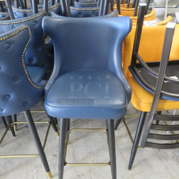 Vintage-look blue bar stool with swivel seat, tufted back, nail head trim, and gold footrest. Excellent condition.
