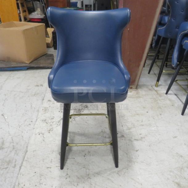 Vintage-style blue cushioned counter height bar stool with swivel seat, tufted back, nail head trim, and gold footrest.