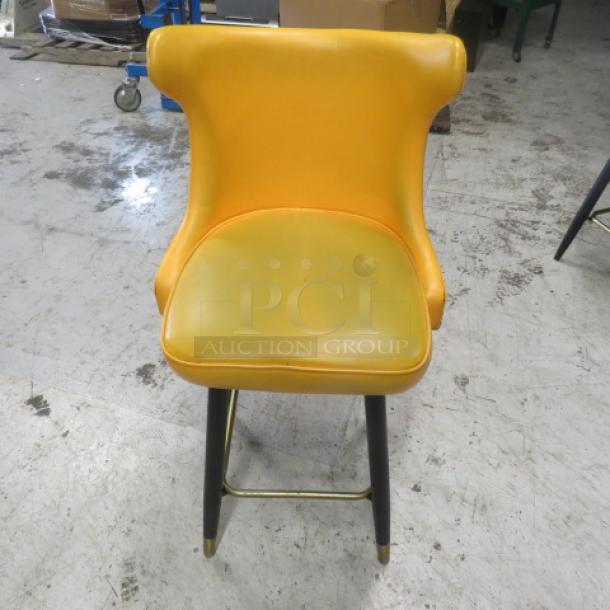 Vintage-style yellow cushioned bar stool with swivel seat, tufted back, nail head trim, and gold footrest. Good condition.