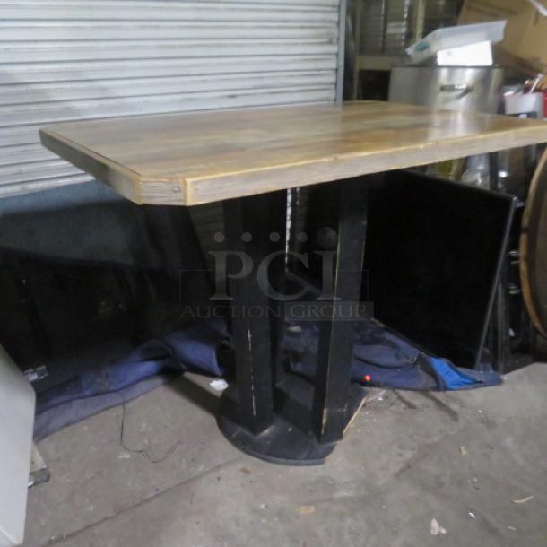 Wooden table with a wooden base, measuring 54x36x43 inches. Features a natural finish and sturdy design. Good condition.