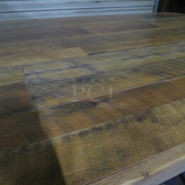 Wooden table with a textured surface, measuring 54x36x43 inches. Made of natural wood with a sturdy wooden base.