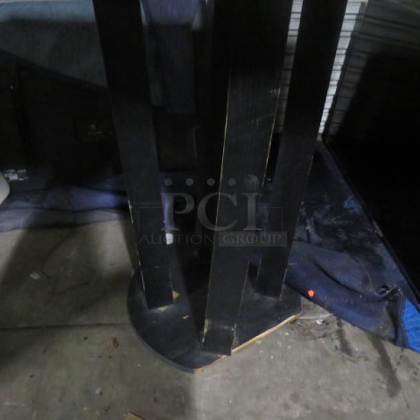 Wooden table with a wooden base, dimensions 54x36x43 inches. Some wear and scuffs visible on the legs.