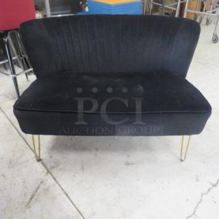 Black cushioned sofa, dimensions 45x32x31 inches, features vertical stitching on backrest, gold metal legs. Good condition.