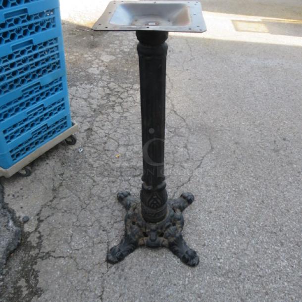 Ornate cast iron base with detailed claw foot design, sturdy condition, ideal for table support or decorative use.