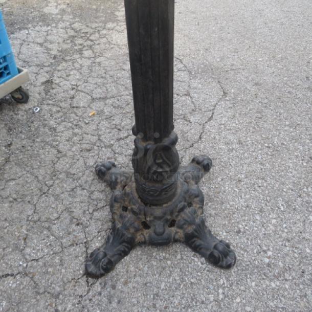 Ornate cast iron base with decorative claw feet, used condition, suitable for tables or stands.