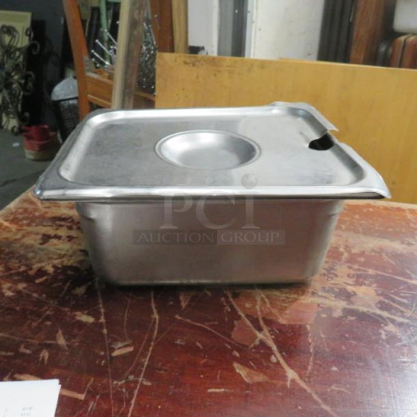 1/2 Size Hotel Pan with Lid, 6-inch deep, metal construction. Used condition, has a small notch on the lid edge.