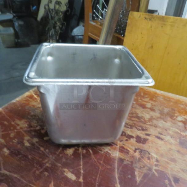 1/6 size, 6-inch deep hotel pan, stainless steel. Used condition with visible wear. Ideal for food service applications.