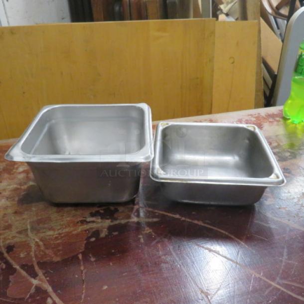 Assorted size metal hotel pans, one deep and one shallow, on a wooden surface; used condition.