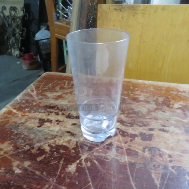 Lot of 12 polycarbonate drinking glasses, clear design, durable, lightly used condition, suitable for various beverages.