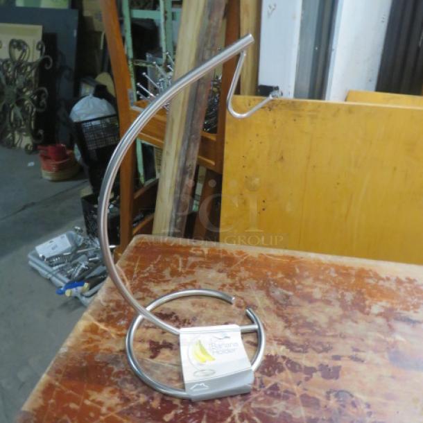 NEW stainless steel banana holder, model 5XBID. Sleek design, sturdy construction, perfect condition, with product label.