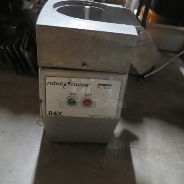 Robot Coupe R4X food processor in used condition, featuring on/off switch and sturdy metal construction.
