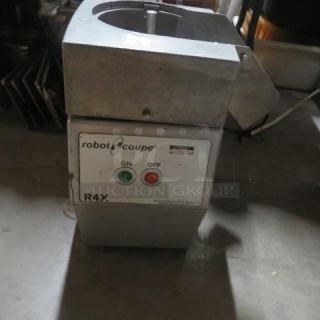 Robot Coupe R4X food processor in used condition, featuring on/off switch and sturdy metal construction.