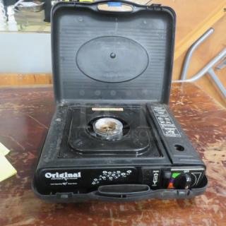 Portable gas range in black carrying case. Features single burner, controls, and "Original" branding. Used condition.
