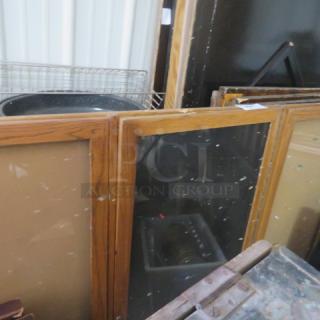 Wooden framed 3-door bulletin board, 72x48 inches, with key. Visible wear on frame, suitable for indoor use.