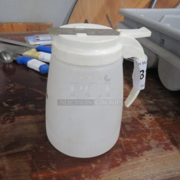 White plastic syrup dispenser with a metal lid and handle. Used condition with a label marked "3".