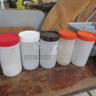 Set of five Store and Pour containers with colored lids; used condition; ideal for kitchen or bar storage and pouring.