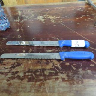 Two Cozzini chef knives with blue handles on a worn wooden surface. One knife has a visible label marked "224".