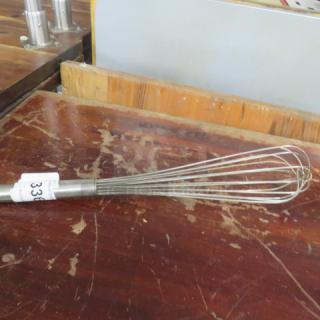 Stainless steel whip whisk on a wooden table, slightly worn condition, numbered tag indicating auction lot "338".