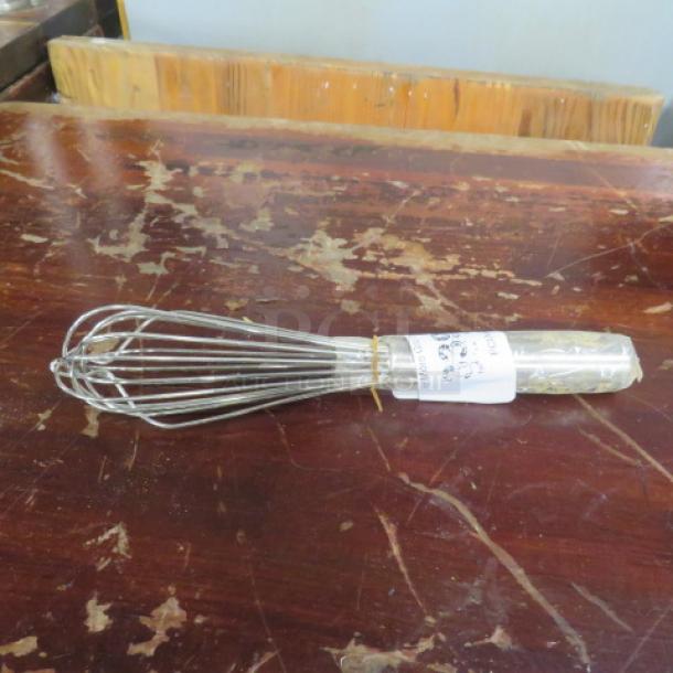 Stainless steel whisk, new with tag, long handle, wire loops, on a textured wooden surface.