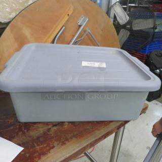 Gray bussing tub with lid on a wooden table. Lid features a white label with the number 349. Used condition.