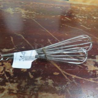 Assorted metal whisks on a worn wooden surface with a paper tag labeled "244," showcasing multiple wire loops.